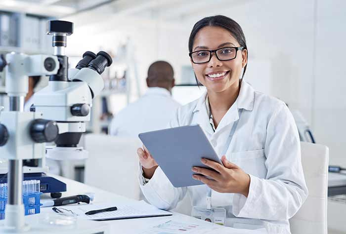 female medical researcher in lab holding clipboard