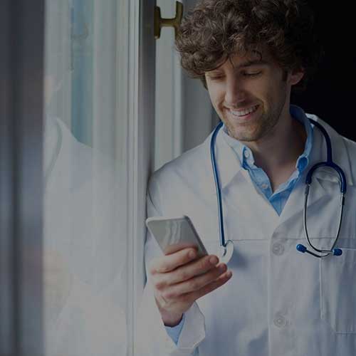 male medical worker looking at his smartphone