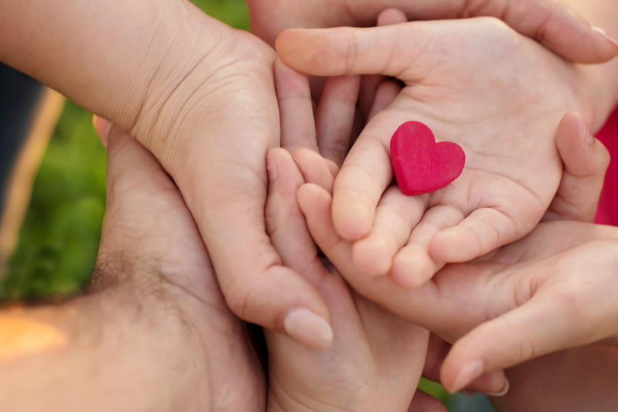 Hands holding a heart image