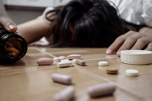 opioid education female collapsed with scattered pills