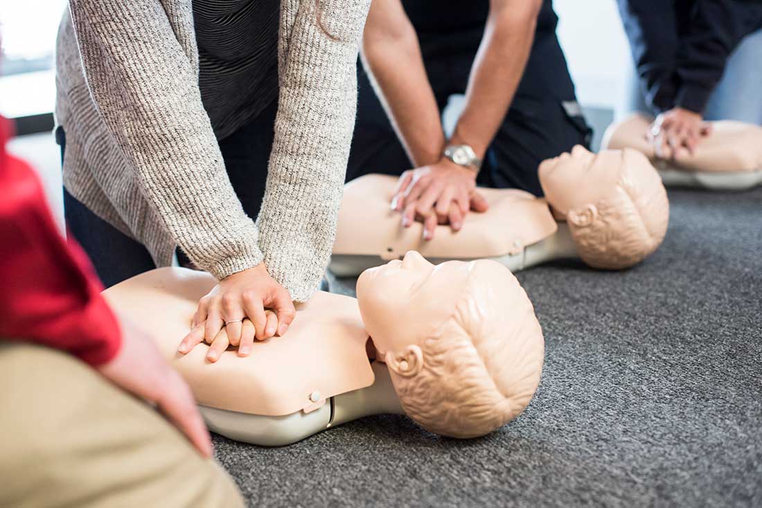 Students practicing CPR on manikins in a CPR class