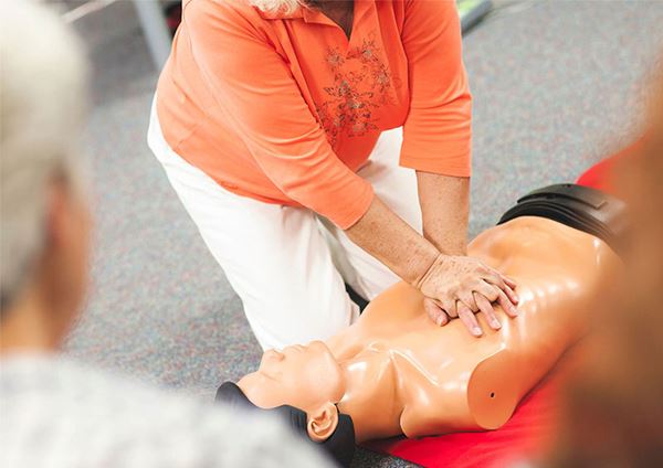 woman illustrating hand placement for CPR woman illustrating hand placement for CPR