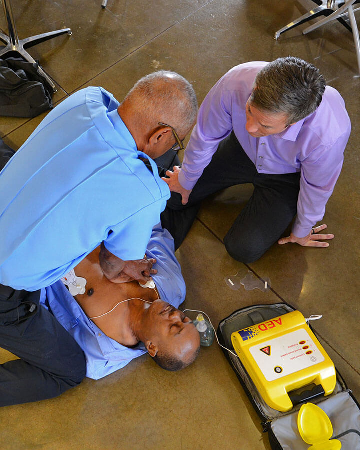 paramedic and office personnel using an AED