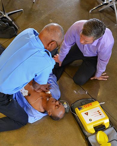 male paramedic and male office personnel using an AED image