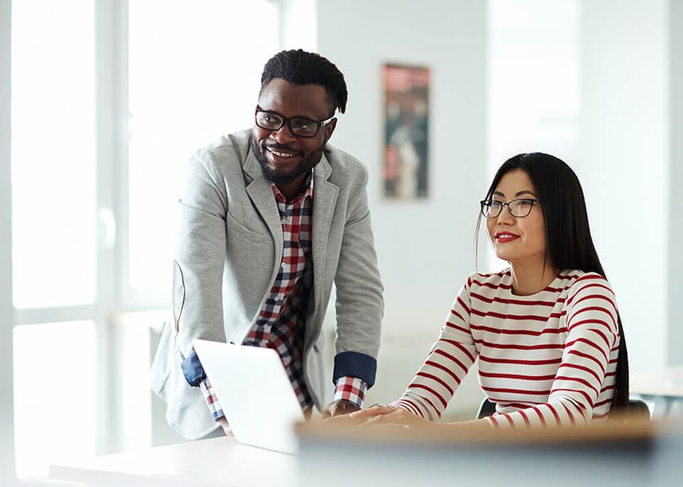 business man and woman viewing resources on a laptop