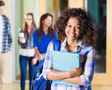 happy college student posing near her friends on campus