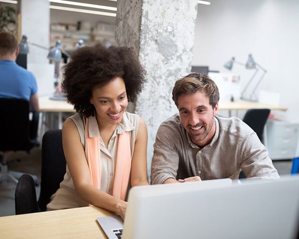 coworkers learning on computer in office