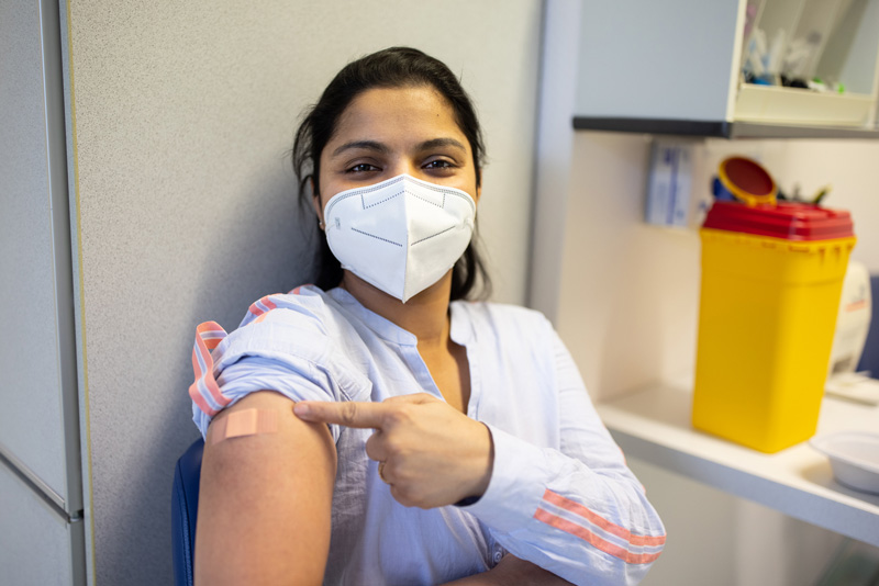 woman showing off where she received vaccine