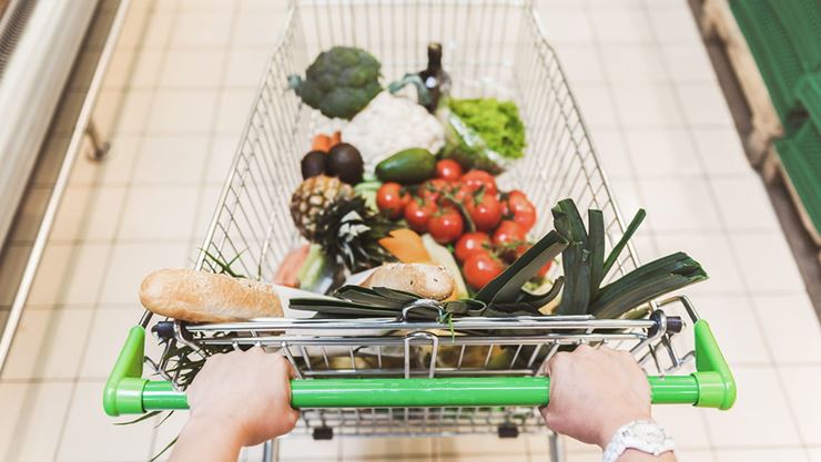 hands pushing grocery cart down isle in store