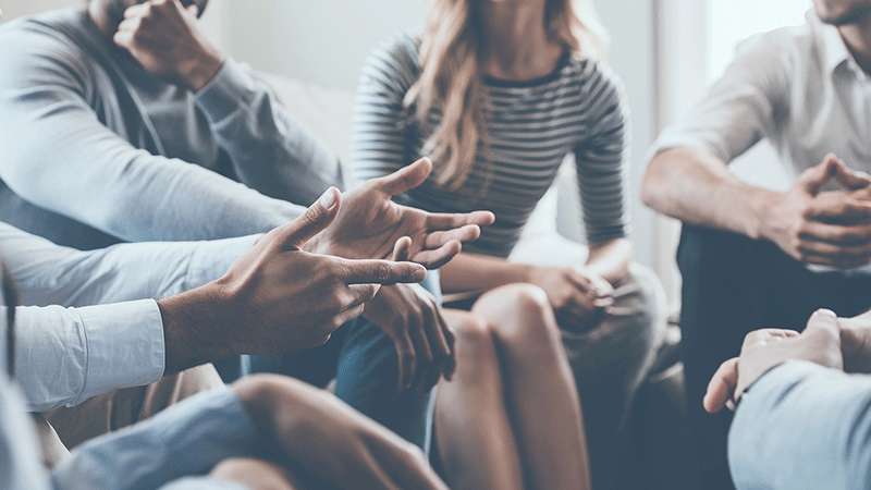 Close up of Multi-ethnic group of people talking in a circle. Therapy