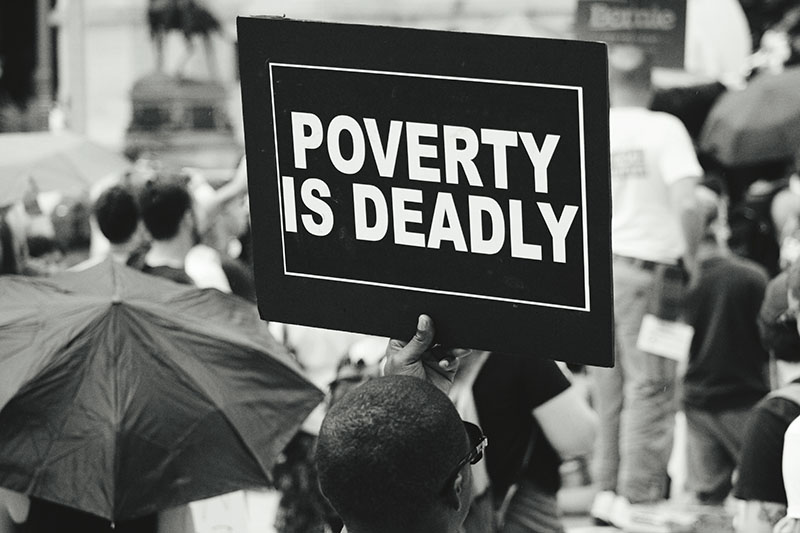 Man holding a poverty is deadly sign