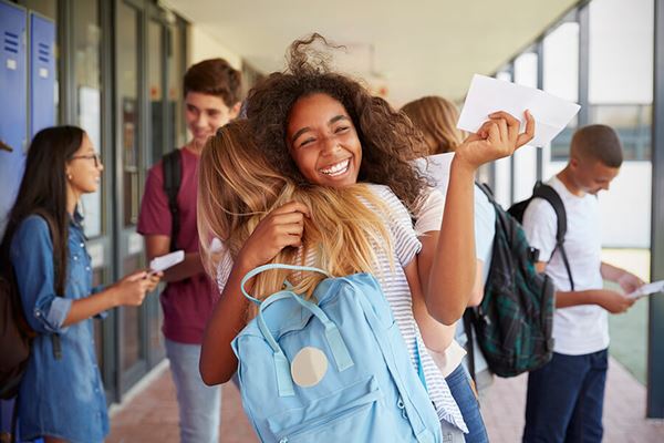 two high school girls celebrating award in school