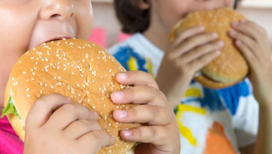 boy and girl eating burgers