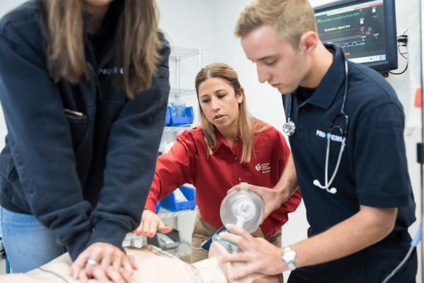 instructor teaching triage CPR to two students instructor teaching triage CPR to two students