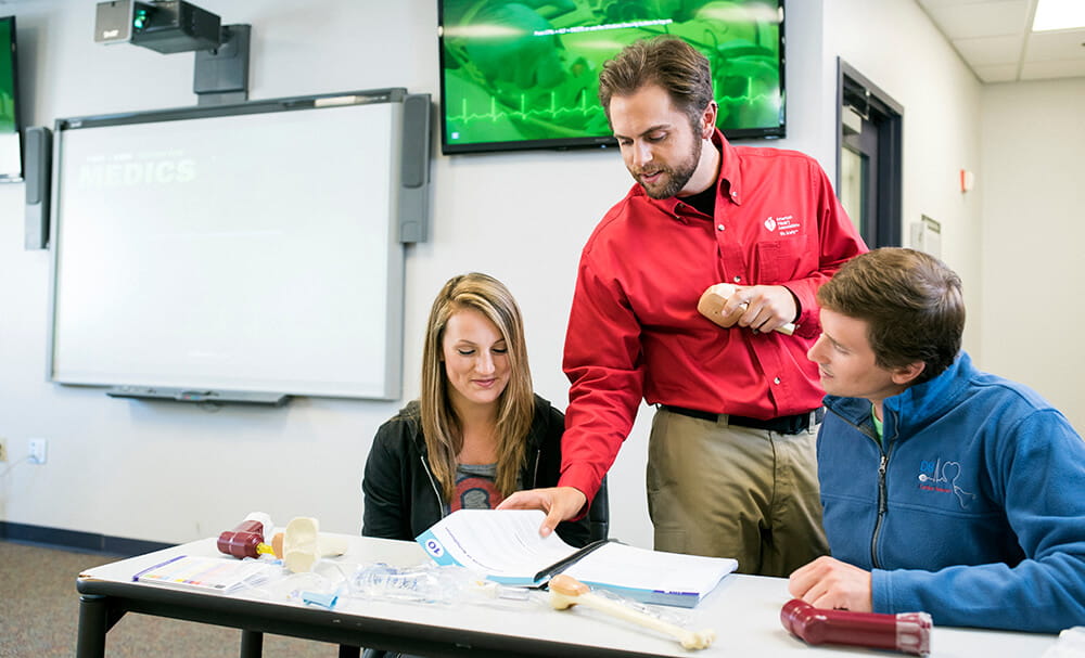 instructor in classroom with two students instructor in classroom with two students